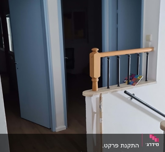 רצפת פרקט עץ במסדרון עם דלתות כחולות